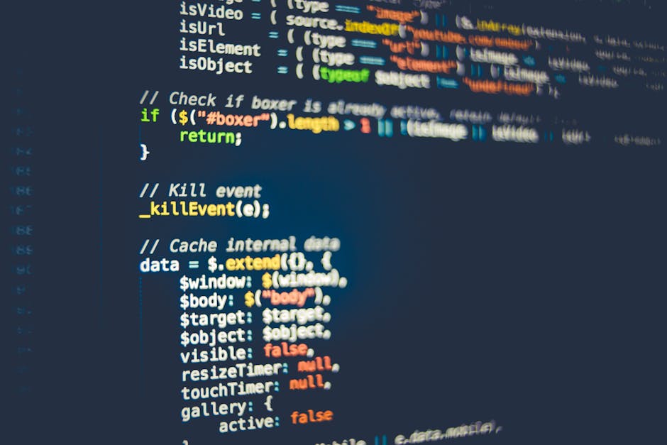 A close-up photograph of a computer screen displaying lines of coloured HTML and CSS code on a dark background, with the code editor interface visible. The code includes text in red, green, blue, and 